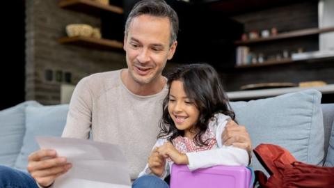 Girl with her father opening letter