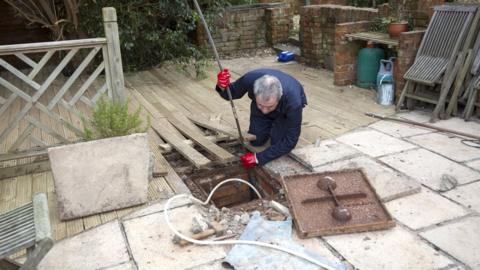 man clearing drain