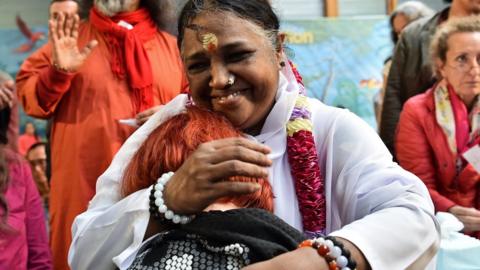 Indian spiritual leader Mata Amritanandamayi (C), popularly know as 'Amma' (The Mother) or also as 'The Hugging Saint,' hugs a woman during a followers's gathering on October 26, 2016 in Paris