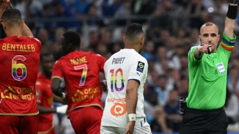 Referee Benoit Millot wearing a LGBTQIA+ rainbow-coloured armband during Marseille's game with Angers on 14 May 2023