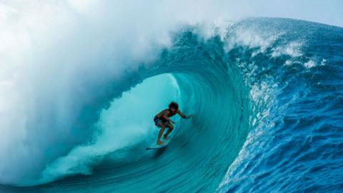 Surfer riding the Teahupo'o wave on the Pacific island of Tahiti