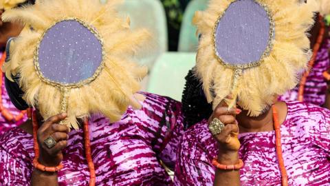 Women cover their faces with stitched, feathered fans in Ijebu, Ogun state, Nigeria - 30 June 2023