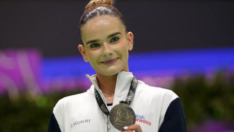 Alice Kinsella holds up her bronze medal at the European Championships