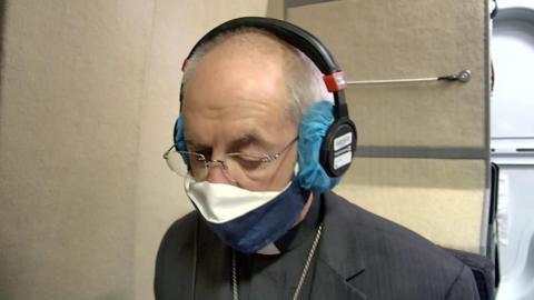 Justin Welby in a radio studio wearing a face mask