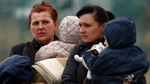 Ukrainian refugees cross the Ukraine-Poland border on 26 March