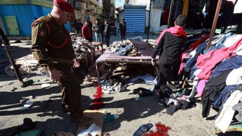 Officials inspect the explosion site after a suicide bombing attack at al-Tayaran Square in Baghdad, Iraq on January 21, 2021