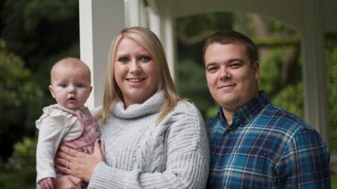 Christie and Jake standing by the gazebo with their five-month-old daughter Hallie