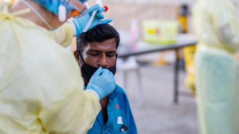 Swab tests are conducted at STLodge migrant workers" dormitory