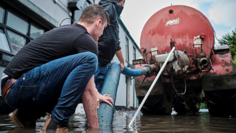 A sileage tanker is used to clear water from the street.