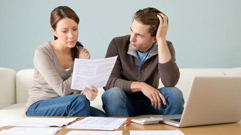 Young couple using computer and doing paperwork