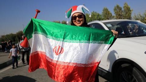 Iranian woman holding a flag