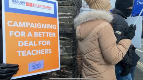 A sign being held up calling for a better deal for teachers