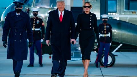 Outgoing US President Donald Trump and First Lady Melania Trump step out of Marine One at Joint Base Andrews