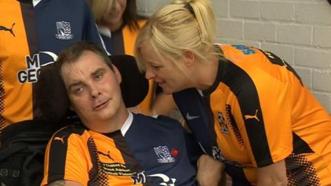 Simon Dobbin and his wife Nicole pitchside at a Cambridge United and Southend United match.