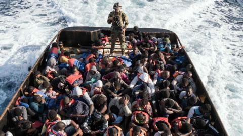 A Libyan coast guardsman stands on a boat during the rescue of 147 illegal immigrants attempting to reach Europe off the coastal town of Zawiyah