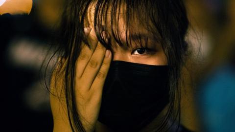 A secondary school student covers one eye with her hand in solidarity with a woman who was injured in the eye, during an anti-government rally at Central, in Hong Kong, China, 22 August 2019