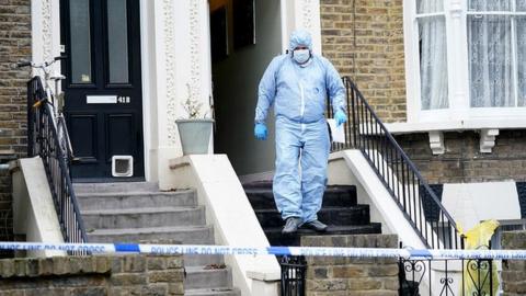 Forensic officers at a property on Montague Road in Dalston, east London,