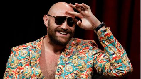 Tyson Fury looks out to the crowd wearing sunglasses