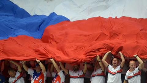 Sport fans hold a giant Czech flag