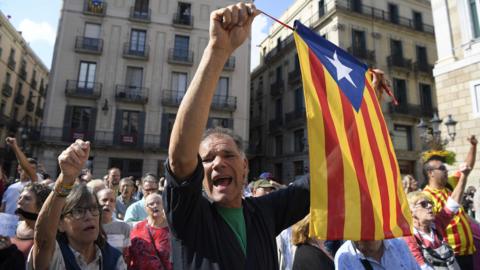 A man waves a stelada (pro-independence Catalan flag) during a protest against the arrest of two Catalan separatist leaders in Barcelona on October 17, 2017