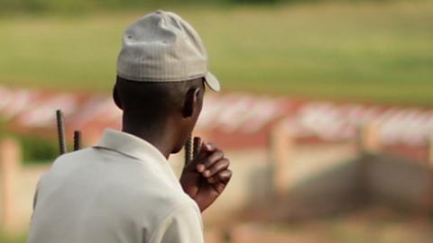 A man sits as the evening sun falls over the Kicukiro District of the capital April 5, 2014 in Kigali, Rwanda.