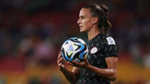 Ashleigh Plumptre holds a football while playing for Nigeria