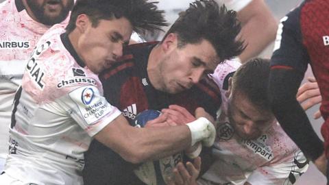 Munster's Joey Carberry is tackled by Toulouse pair Ange Capuozzo and Anthony Jelonch