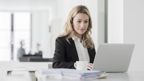 Businesswoman working in office on laptop computer