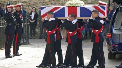 Pallbearers carry the coffin of Major General Matthew Holmes, the former head of the Royal Marines, into Winchester Cathedral