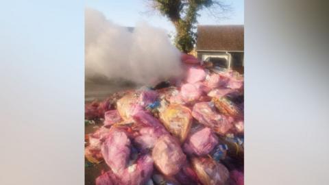 Smoke coming from a pile of bin bags