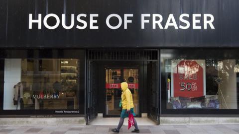 House of Fraser Cardiff store as a sole woman shopper walks past