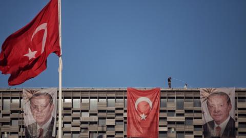 Posters of Turkey's President Recep Tayyip Erdogan and a Turkish flag hangs on Ataturk Cultural Center at Istanbul's central Taksim on July 19, 2016 in Istanbul, Turkey