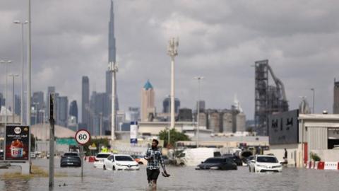 A man in floodwater in Dubai