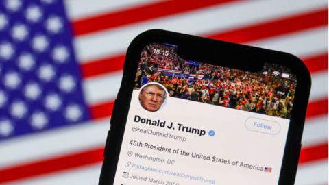 An illustration photo of Mr Trump's Twitter feed with American flag in background