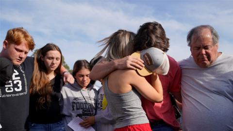 People console each other at a vigil after the shooting.
