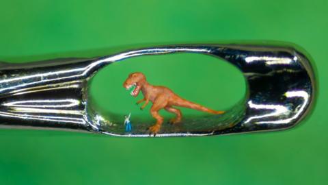 Micro-sculpture of T. rex through the eye of a needle