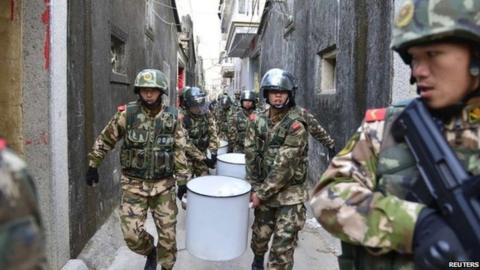 Paramilitary policemen carry seized crystal meth at Boshe village