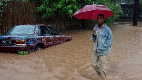 A man wades through rising floodwaters in Pemba, Mozambique after Cyclone Kenneth struck the African nation