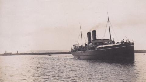 Black and white photo of the RMS Leinster leaving port on a calm sea