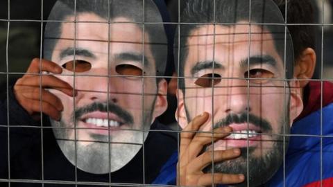 Nacional fans holding Luis Suarez masks