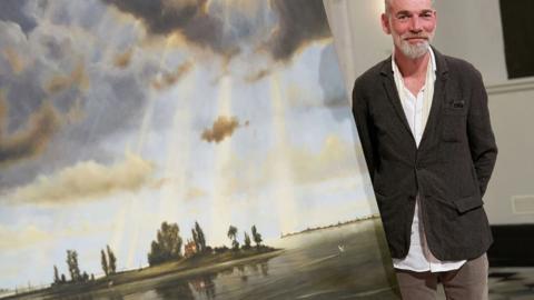 Artist Finn Campbell-Notman beside his winning artwork