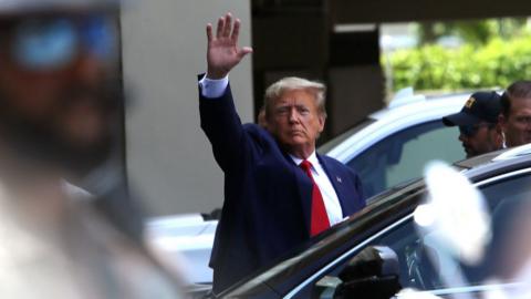 Former President Donald Trump waves as he makes a visit to the Cuban restaurant Versailles after he appeared for his arraignmen