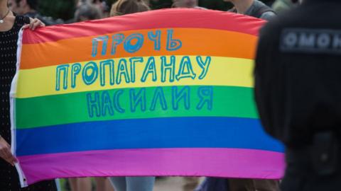 A pride flag with Russian text reading "Stop propaganda of violence"