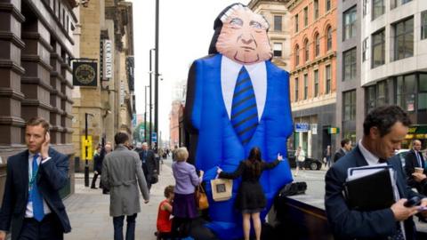 Protesters calling to close the widening gap between 'fat cat' executive pay deals and those of regular workers demonstrate outside the annual Conservative Party Conference