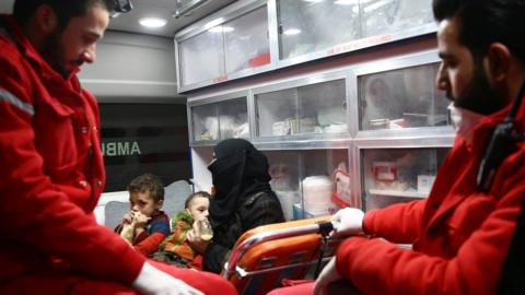 A woman is seen with her children in an ambulance during a medical evacuation from the besieged rebel-held town of Douma, in the Eastern Ghouta outside Damascus, Syria (26 December 2017)