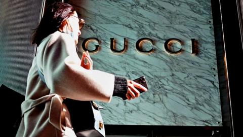 A woman walks in front of the Gucci store on Fifth Avenue in Trump Tower.