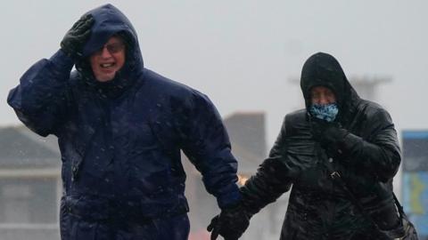 People brave the weather as they make their way along the sea front in Southsea as Storm Barra hit the UK and Ireland with disruptive winds, heavy rain and snow on Tuesday.