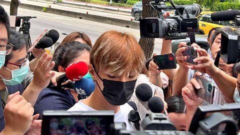Aaron Yan, who is accused raping his ex-boyfriend, is surrounded by reporters as he arrives at a police station for further investigation on 3 July 2023 in Taipei, Taiwan