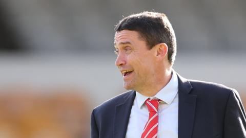 Swindon Town chief executive Rob Angus chatting before a League Two match.