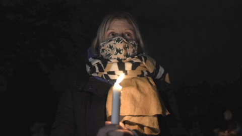 Woman with a candle at the vigil